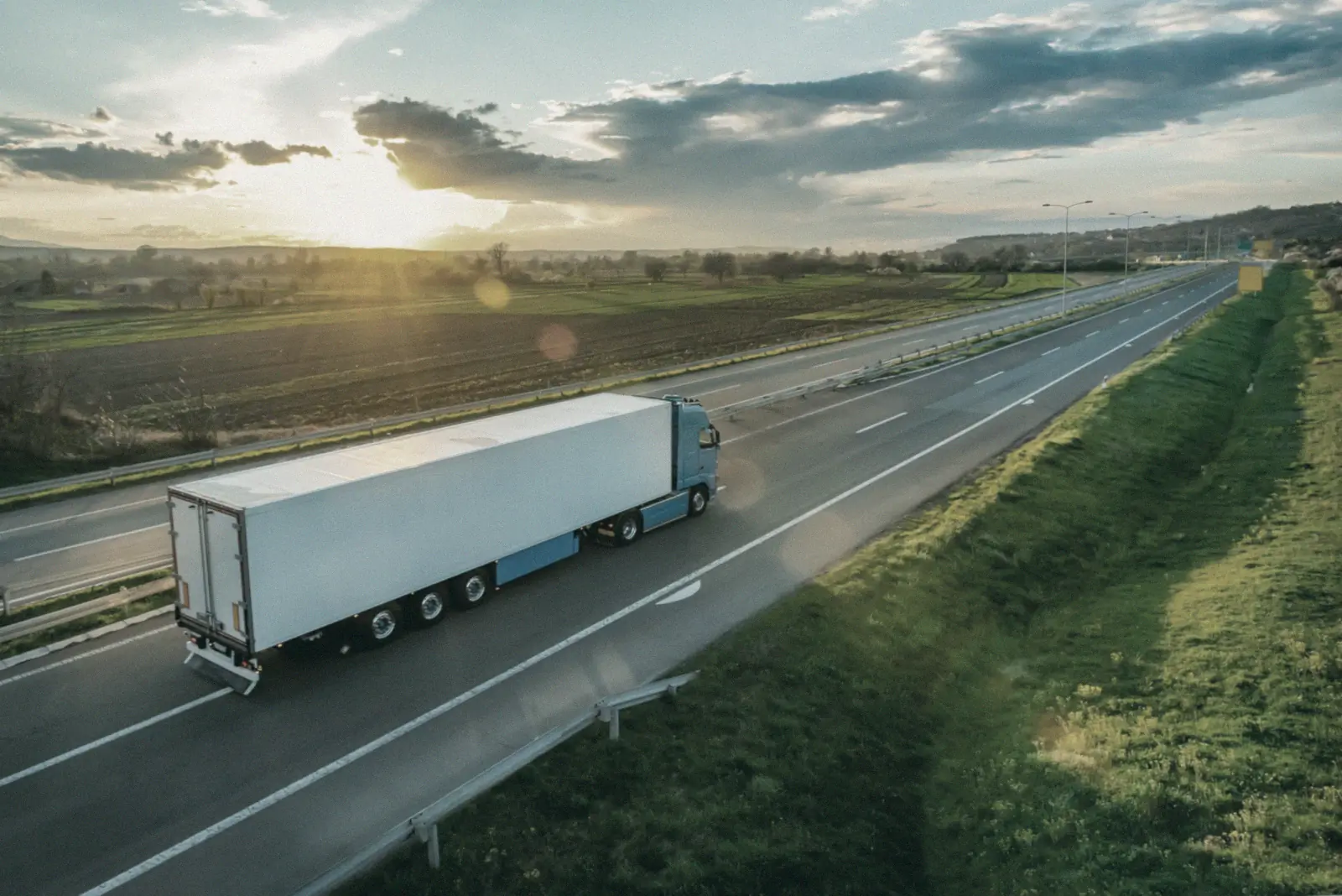 Truck with trailer on a motorway at sunset